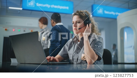 Airport Security Checkpoint: Female Security Officer Talking on Headset, Using Laptop Computer 123827753