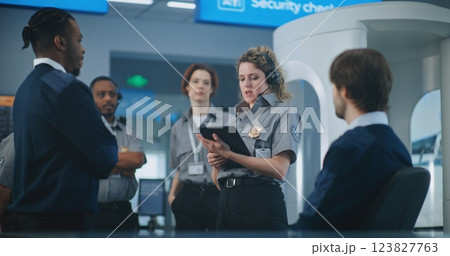 Female Security Officer in Headset Instructs Airport Staff About TSA Screening Procedures 123827763