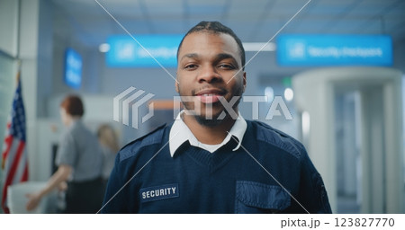 Airport Security Checkpoint: Portrait of TSA Worker Smiling and Looking at Camera 123827770
