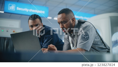Airport Security Checkpoint: Security Officers Using Laptop Computer and Talking 123827814