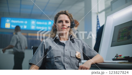 Portrait of Female Security Officer Sitting at Control Panel of X-ray Scanner, Looking at Camera Portrait of Female Security Officer Sitting at Control Panel of X-ray Scanner, Looking at Camera 123827824