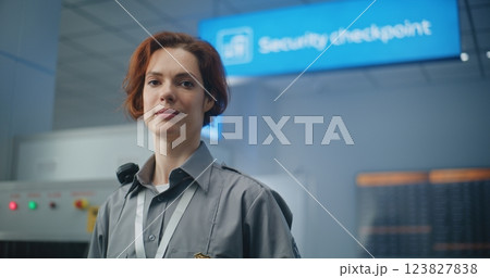 Airport Security Checkpoint: Portrait of Female TSA Worker Smiling and Looking at Camera Airport Security Checkpoint: Portrait of Female TSA Worker Smiling and Looking at Camera 123827838