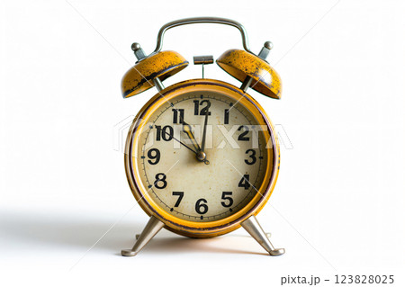 Antique style yellow alarm clock displaying the time, standing isolated on a white backdrop with shadow, facing frontally Antique style yellow alarm clock displaying the time, standing isolated on a white backdrop with shadow, facing frontally 123828025