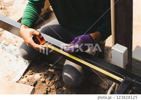 Ironworker measuring with hand holding a pen in building site. Ironworker measuring with hand holding a pen in building site. 123828125
