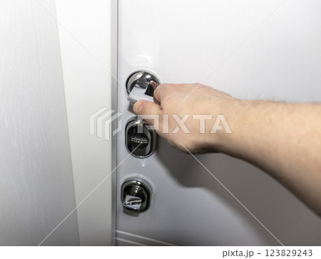 White door with metal handle and locks as a part of interior design White door with metal handle and locks as a part of interior design 123829243
