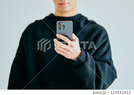 スマホを操作する20代の若い男性 123832412