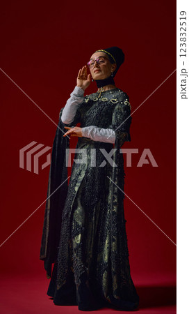 Elderly woman in detailed renaissance dress adjusting stylish modern glasses with composed expression, blending historical refinement with contemporary intellect . Elderly woman in detailed renaissance dress adjusting stylish modern glasses with composed expression, blending historical refinement with contemporary intellect . 123832519