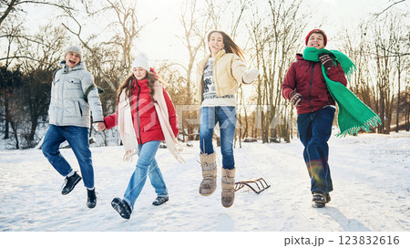 Group of friends joyfully jumping in snow, sharing playful winter moment together in public park cowered with snow. Group of friends joyfully jumping in snow, sharing playful winter moment together in public park cowered with snow. 123832616
