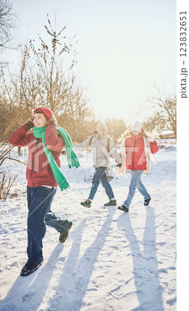 Group of young cheerful people, men and woman, dressed stylish cozy clothes, walking together among snowy park on sunny winter day, sharing moments. Group of young cheerful people, men and woman, dressed stylish cozy clothes, walking together among snowy park on sunny winter day, sharing moments. 123832651