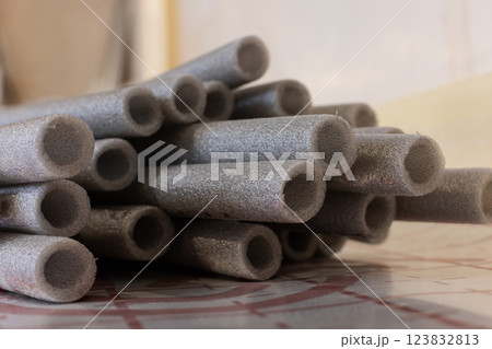 Grey soft isolation for pipes of the water supply and heating system. Closeup, selective focus. 123832813