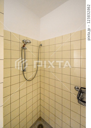 A contemporary shower room featuring tiled walls, a chrome shower head, and a minimalistic aesthetic. Ideal for inspiration in bathroom renovations. 123832862