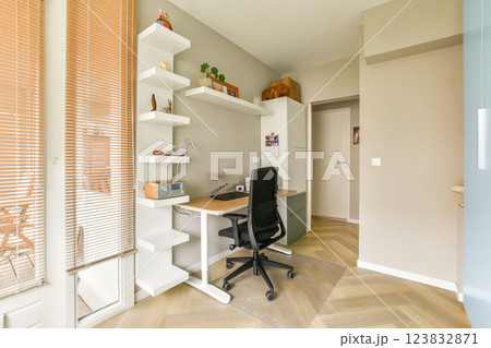 A stylish and organized home office setup featuring a sleek desk, comfortable chair, and minimalist shelves, perfect for productivity and aesthetics. 123832871