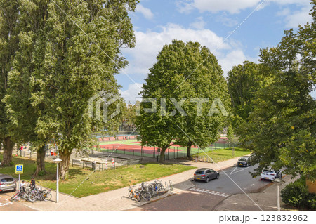 A vibrant outdoor scene featuring lush trees, a park area, and sports courts, showcasing the beauty of community spaces in urban settings. A vibrant outdoor scene featuring lush trees, a park area, and sports courts, showcasing the beauty of community spaces in urban settings. 123832962