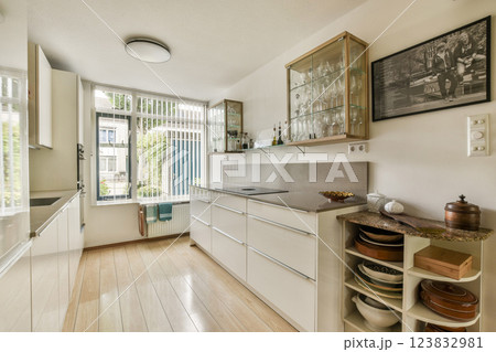 Bright and spacious kitchen showcasing sleek cabinetry and modern design, illuminated by abundant natural light through large windows. Bright and spacious kitchen showcasing sleek cabinetry and modern design, illuminated by abundant natural light through large windows. 123832981