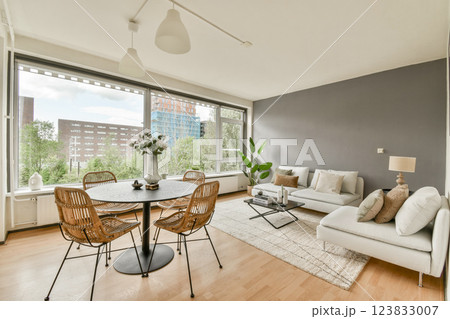 Featuring a stylish design, this living room offers modern furniture and a serene outdoor view through large windows, creating a cozy atmosphere for relaxation. 123833007