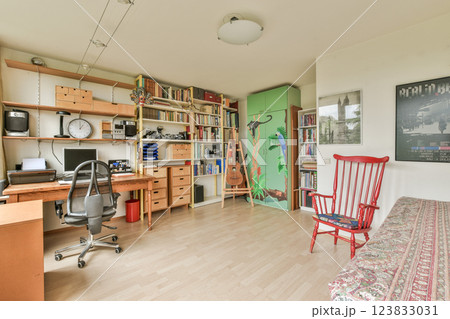 A stylish home office featuring a desk, bookshelves filled with books, and decorative elements. The room combines functionality with a welcoming atmosphere. A stylish home office featuring a desk, bookshelves filled with books, and decorative elements. The room combines functionality with a welcoming atmosphere. 123833031