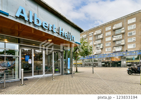 A vibrant urban landscape featuring the storefront of an Albert Heijn grocery store amidst residential buildings, capturing everyday life in the city. A vibrant urban landscape featuring the storefront of an Albert Heijn grocery store amidst residential buildings, capturing everyday life in the city. 123833194
