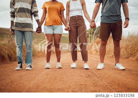 Legs, diversity and people holding hands together in solidarity, connection or support. Trust, friendship help and outdoor desert group, team or friends walk, travel or stand in countryside dirt road 123833198
