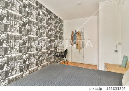 A cozy modern bedroom featuring stylish wallpaper, minimalist furniture, and a harmonious color palette, ideal for contemporary living. A cozy modern bedroom featuring stylish wallpaper, minimalist furniture, and a harmonious color palette, ideal for contemporary living. 123833295