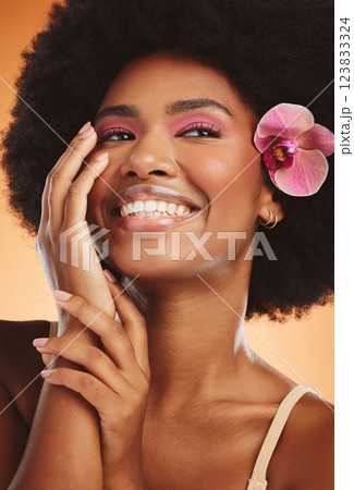 Flower, model and makeup with afro in closeup for fashion, cosmetic or beauty with orange backdrop. Woman, pink orchid and hair for cosmetics with smile, happy and glow on skin with studio background Flower, model and makeup with afro in closeup for fashion, cosmetic or beauty with orange backdrop. Woman, pink orchid and hair for cosmetics with smile, happy and glow on skin with studio background 123833324