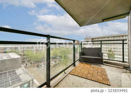 A spacious balcony showcasing a modern design and a vibrant cityscape view under a bright sky. Ideal for relaxation or enjoying an outdoor atmosphere. A spacious balcony showcasing a modern design and a vibrant cityscape view under a bright sky. Ideal for relaxation or enjoying an outdoor atmosphere. 123833491
