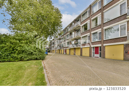 A scenic view of a residential street lined with greenery and modern apartments. The area features a calm atmosphere with well-maintained surroundings. A scenic view of a residential street lined with greenery and modern apartments. The area features a calm atmosphere with well-maintained surroundings. 123833520