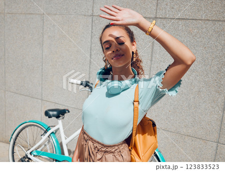 City, girl and hand shield for sun exposure on outdoor commute break at urban concrete wall. Young bike traveler woman hiding face from direct sunshine for shade protection in summer. 123833523