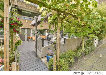 A beautifully designed outdoor seating area featuring comfortable furniture and vibrant flowers, creating a serene escape for relaxation and gatherings. 123833719