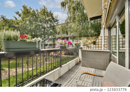 A beautifully arranged balcony featuring vibrant flowers and greenery, perfect for relaxation and enjoying nature in an urban setting. A beautifully arranged balcony featuring vibrant flowers and greenery, perfect for relaxation and enjoying nature in an urban setting. 123833776