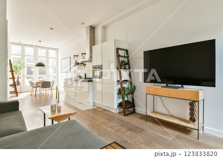 A stylish modern living space featuring a cozy seating area, large windows for natural light, and contemporary furniture design. Ideal for relaxation and socializing. A stylish modern living space featuring a cozy seating area, large windows for natural light, and contemporary furniture design. Ideal for relaxation and socializing. 123833820