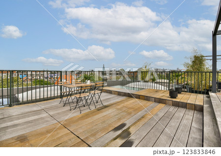 A beautifully designed rooftop space featuring wooden flooring and a clear view of the sky, perfect for relaxation and gatherings. 123833846