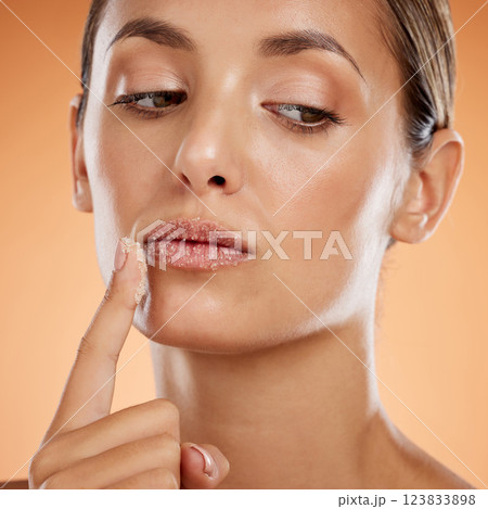 Face, beauty and lips, woman and scrub, natural makeup and skincare product advertising with orange studio background. Cosmetics, fresh and clean, facial and lip treatment, wellness and glow closeup 123833898