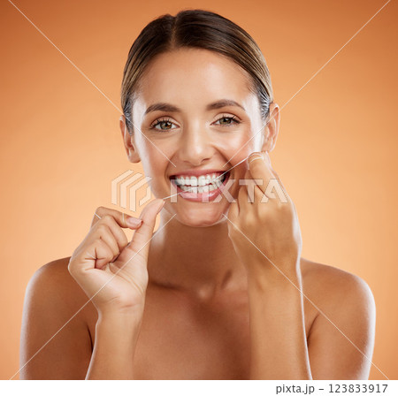Woman, dental flossing and teeth with smile for clean hygiene and health against a studio background. Portrait of a happy toothy woman smiling in beauty floss for hygienic mouth, oral and gum care 123833917