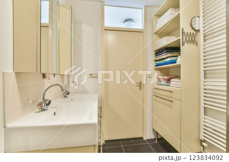 Stylish and minimalist bathroom featuring sleek cabinetry, organized towels, and contemporary fixtures, creating a vibrant yet serene ambiance. Stylish and minimalist bathroom featuring sleek cabinetry, organized towels, and contemporary fixtures, creating a vibrant yet serene ambiance. 123834092