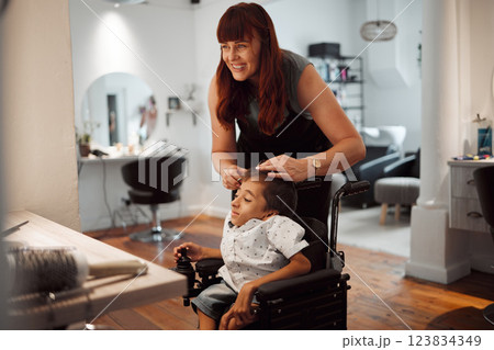 Hairdresser, barber and disability for child in wheelchair in salon, parlour or barbershop. Stylist, woman and happy for service to disabled kid with cerebral palsy in shop, store or small business 123834349