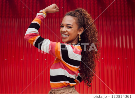 Beauty, fashion and strong with a black woman flexing her bicep outdoor on a red background with a smile. Empowerment, proud and strength with an attractive young female showing her arm muscle 123834361