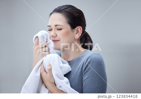 Laundry, woman smelling clean towel and the scent of fresh clothes from washing basket or machine. Housekeeping, cleaning and mom or housekeeper with the nice smell of fabric detergent in happy home 123834418