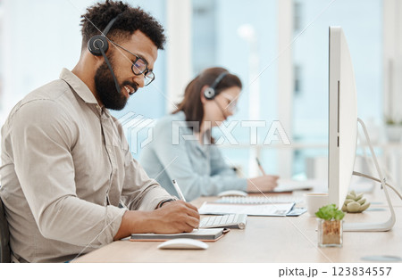 Customer support, writing and businessman at computer in call center office for telemarketing, consulting and phone call. Communication, contact and sales with employee and kpi or crm with notebook 123834557