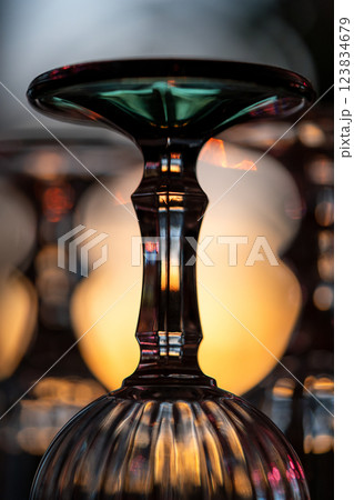 Closeup of an upturned faceted wine glass illuminated by sunset light Closeup of an upturned faceted wine glass illuminated by sunset light 123834679