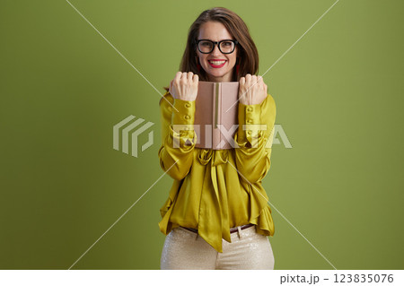 smiling woman in green blouse and glasses isolated on green 123835076