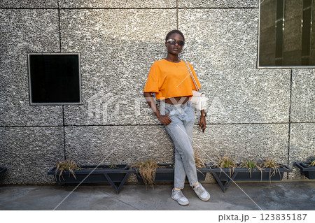 Portrait of cheerful stylish black woman student posing happily. Personal expression with clothes Portrait of cheerful stylish black woman student posing happily. Personal expression with clothes 123835187