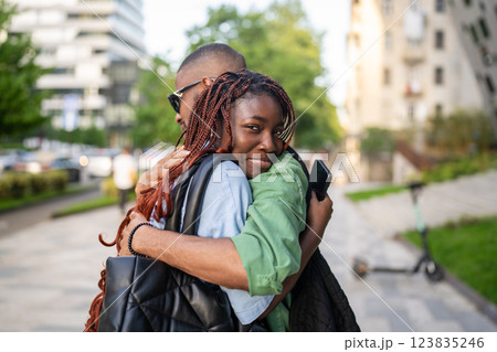 Sad African American couple hug goodbye, woman reluctant to let go on street. Separation, move away 123835246