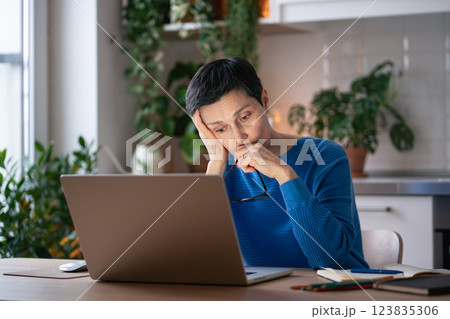 Burned out sad woman at home, suffers headache from excessive screen time and work stress at laptop 123835306