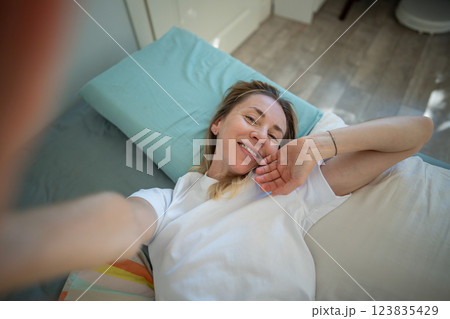 Smiling relaxed woman gently wakes up, stretching to camera. Sleep schedule, happy morning balance 123835429