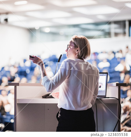 Female speaker giving a talk on corporate business conference. Unrecognizable people in audience at conference hall. Business and Entrepreneurship event Female speaker giving a talk on corporate business conference. Unrecognizable people in audience at conference hall. Business and Entrepreneurship event 123835538