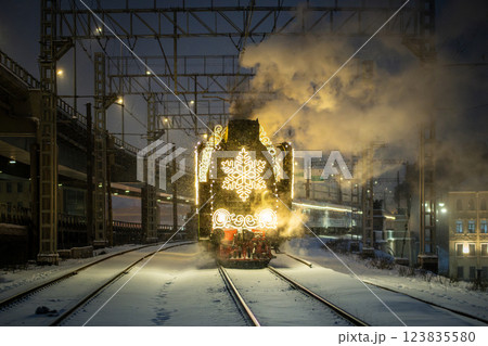 Retro Christmas steam train at night in the city on Christmas Eve and New Year in Russia. Retro Christmas steam train at night in the city on Christmas Eve and New Year in Russia. 123835580