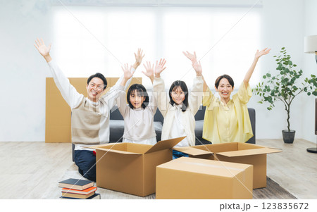家で荷造りしながらバンザイする家族 123835672