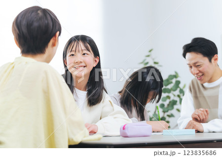 勉強する二人の女の子と指導する男女 123835686