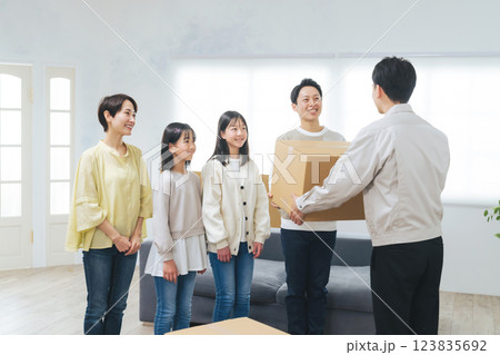 男性スタッフと荷物を受け渡す家族 男性スタッフと荷物を受け渡す家族 123835692