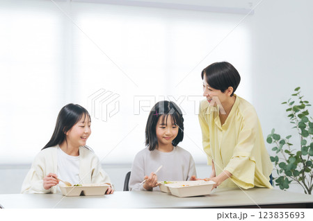 子どもにお弁当を提供する女性スタッフ 123835693